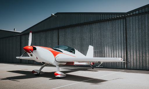 Single Engine Plane With Metal Hangar in the Background